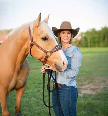Amanda Dockery in cowboy hat with her horse